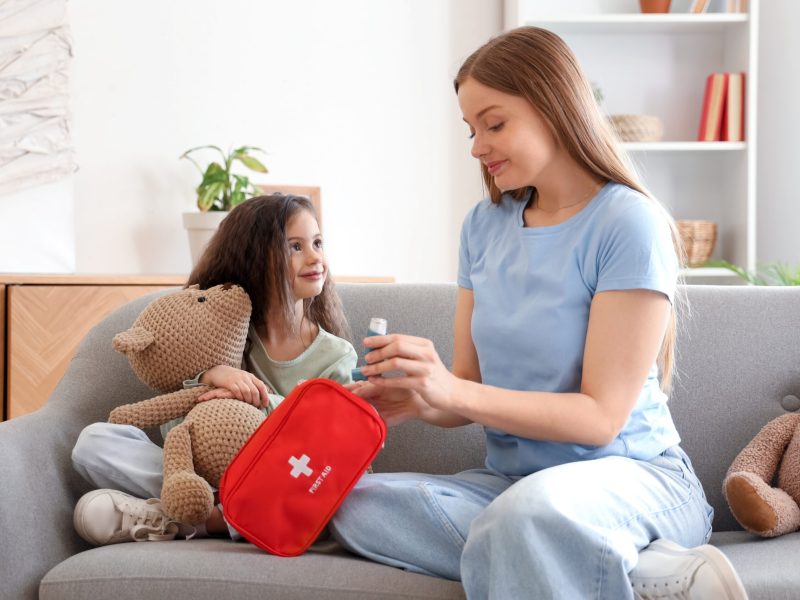 Little,Girl,With,Toy,And,Her,Mother,Taking,Inhaler,From
